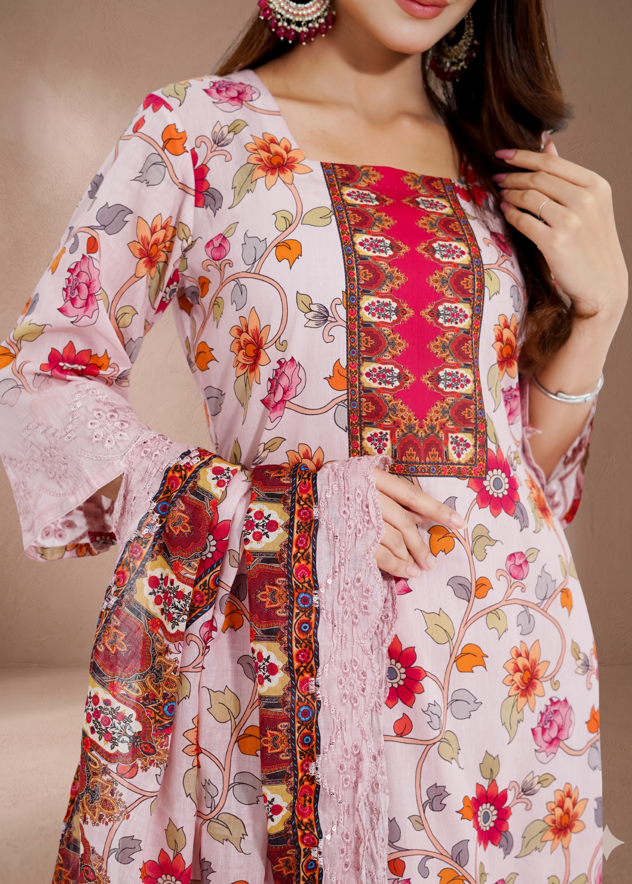 Woman wearing a floral and patterned outfit with a neutral background